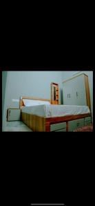 a bedroom with a large bed with a wooden frame at Corniche inn river view villa 2 BHK in Kāsaragod