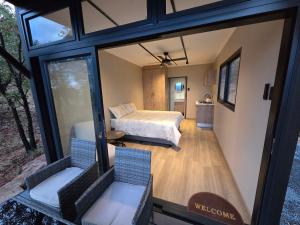 a view of a bedroom with a bed and a window at Lazy Hill Eco Lodge in Warmbaths