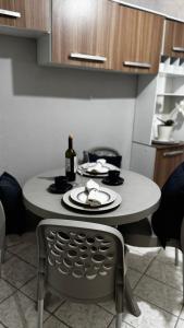 a small table in a kitchen with a bottle of wine at Cantinho Muriu in Ceará-Mirim