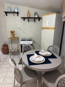 a kitchen with a table and chairs and a refrigerator at Cantinho Muriu in Ceará-Mirim