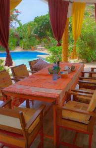 a table and chairs with a table and a pool at Villa Symphonie Saly in Saly Portudal