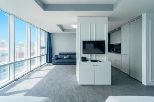 a living room with a couch and a television at Sun Cloud Hotel in Busan