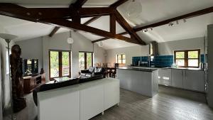 a large kitchen with white cabinets and a table at Peacock Barn in Walsoken