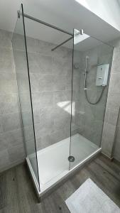 a shower with a glass door in a bathroom at Peacock Barn in Walsoken