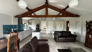 a living room with a couch and a kitchen at Peacock Barn in Walsoken +41 photos