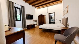 a bedroom with a bed and a desk and a chair at Antico Monastero del Lavello in Calolziocorte