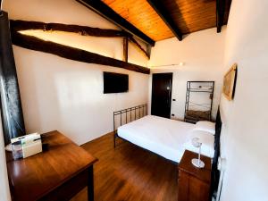 a bedroom with a bed and a desk and a tv at Antico Monastero del Lavello in Calolziocorte