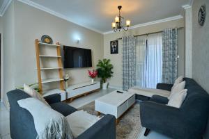 a living room with two couches and a tv at 4 Bedroom Apartment Near JKIA & SGR in Nairobi