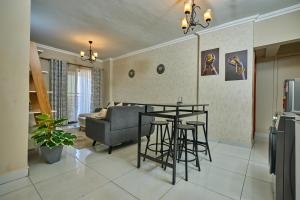 a kitchen and living room with a table and a couch at 4 Bedroom Apartment Near JKIA & SGR in Nairobi