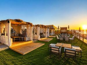a row of tents with tables and chairs on the grass at XU Sidi Abdel Rahman Resort & Spa in El Alamein