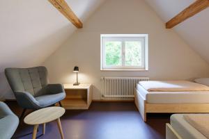 a bedroom with a bed and a chair and a window at Schaffhausen Youth Hostel in Schaffhausen