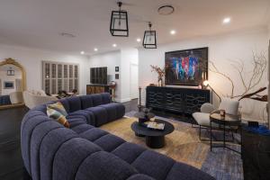 a living room with blue couches and a tv at Wayside Zenhill Retreat Bowral Event & Farm in Glenquarry