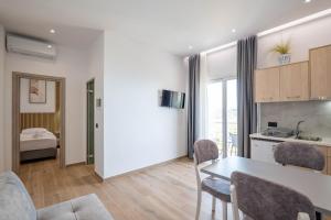 a kitchen and living room with a table and chairs at Ionian View Rooms in Himare