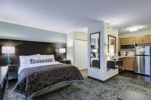 a hotel room with a bed and a kitchen at Staybridge Suites O'Fallon Chesterfield by IHG in O'Fallon