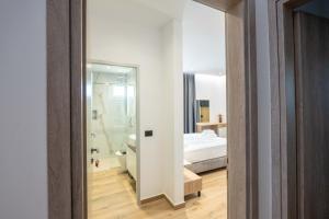 a room with a bed and a bathroom with a mirror at Ionian View Rooms in Himare +86 photos