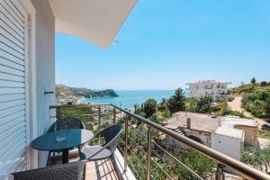 a balcony with a table and chairs and the ocean at Ionian View Rooms in Himare