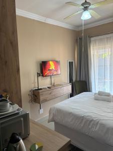 a bedroom with a bed and a flat screen tv at Urban Rest Guesthouse in Mahikeng