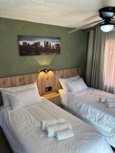 two beds in a hotel room with towels on them at Urban Rest Guesthouse in Mahikeng +70 photos