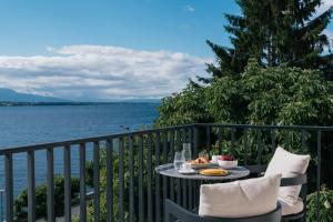 a table with food on a balcony overlooking the water at Beau-Rivage Nyon in Nyon