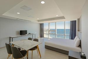 a bedroom with a bed and a table with chairs at Sun Cloud Hotel in Busan