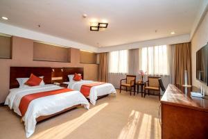 a hotel room with two beds and a desk at Xin Hua Hotel Guangzhou in Guangzhou +28 photos