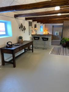 a living room with a wooden table and a kitchen at Gæstehuset in Tarm