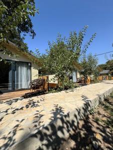 a sidewalk in front of a house with trees at SELKINCHEK resort in Kugart