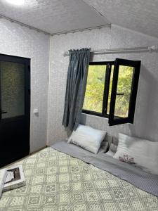 a small room with a bed with a window at SELKINCHEK resort in Kugart