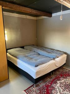 a bed in a corner of a room at Gæstehuset in Tarm