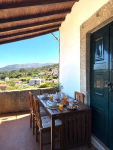 a wooden table with food on it on a balcony at Casas da Loureira in Gondarém