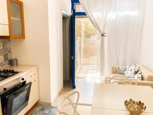 a kitchen with a table and a living room at Pietra & Mare Ostuni in Villanova di Ostuni +8 photos