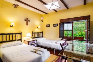 two beds in a room with a window at La Casa de Torre in Ribadesella +20 photos