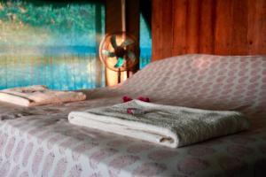 a bed with a blanket on it with a window at Kitu Kiblu in Kilindoni