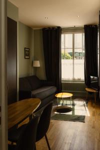 a living room with a couch and a table at Hôtel Helzear Montparnasse by Esteem in Paris