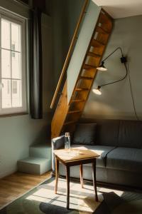 a living room with a couch and a table at Hôtel Helzear Montparnasse by Esteem in Paris