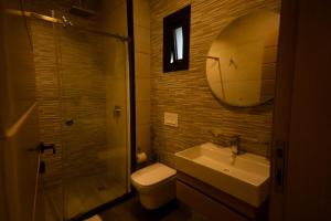 a bathroom with a toilet and a sink and a mirror at Elegant Hillside Ocean Stay in Freetown +7 photos
