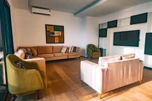 a living room with two couches and chairs at Elegant Hillside Ocean Stay in Freetown