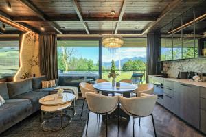 a living room with a couch and a table and chairs at Crystal Peak Villas z prywatnym jacuzzi, Odkryj-Zakopane in Kościelisko +38 photos