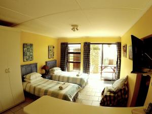 a hotel room with two beds and a balcony at Sandown Self-Catering in Cape St Francis