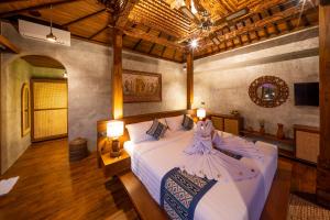 a bedroom with a bed with a dress on it at Bi Bi Bliss Ubud Villa in Ubud