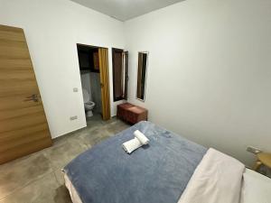 a bedroom with a bed with two white towels on it at Arsenia Cottage D - Kyperounta in Kyperounda