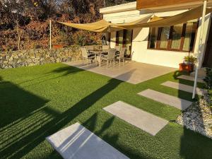 a patio with a table and chairs on a lawn at Arsenia Cottage D - Kyperounta in Kyperounda