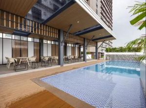 a swimming pool with tables and chairs and a building at JTower Residences Mandaue in Mandaue City