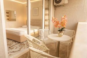 a small room with a bed and a table and chairs at Leonard's Shengjin Apartments in Lezhë