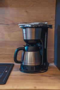 a coffee maker on a table next to a laptop at Appartementhaus Bergkristall in Kartitsch