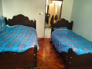 a bedroom with two beds and a mirror at Mutabari's Home in Kitengela 