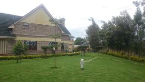 a house with a yard with trees in front of it at Mutabari's Home in Kitengela 