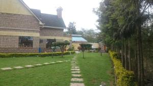 a house with a lawn with a path in front of it at Mutabari's Home in Kitengela 