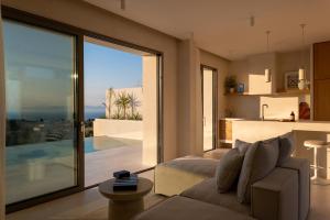 a living room with a couch and a large glass window at CAPO LEFKADA Villa 71 - Sea View - Two Private Pools in Tsoukalades