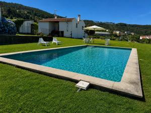 a swimming pool in the yard of a house at Casas da Loureira in Gondarém